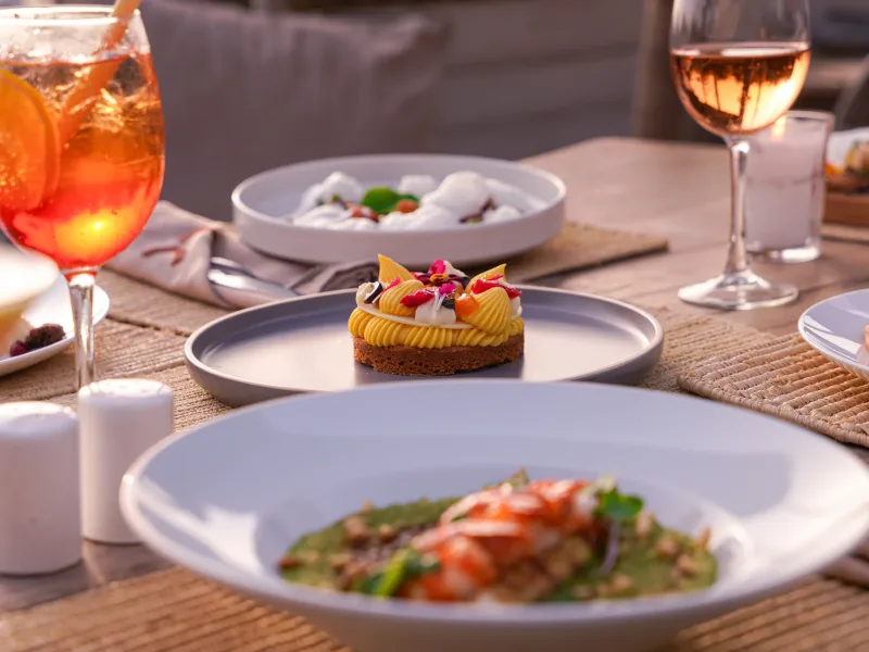 Assiettes et cocktails en terrasse au coucher du soleil à La Coupole