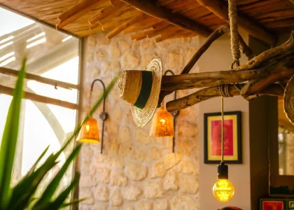 Hat and wall light on a stone wall at La Coupole Essaouira Beach