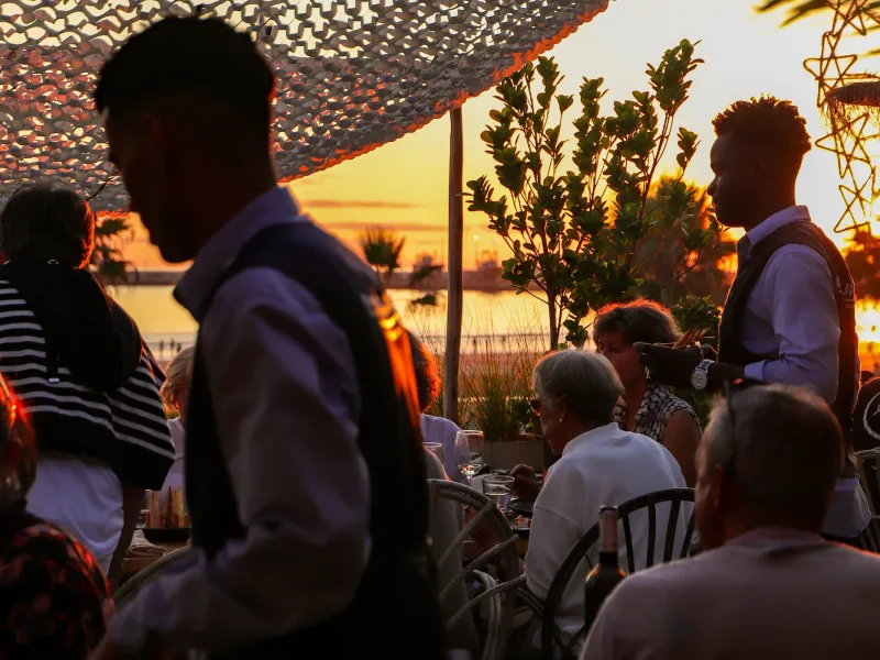 Convives au coucher du soleil sur la terrasse de La Coupole