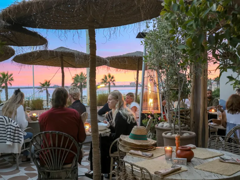 Convives en terrasse au crépuscule à La Coupole Essaouira Beach