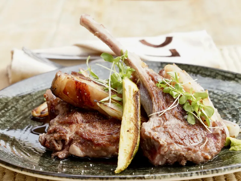 Côtelettes d’agneau grillées sur assiette verte à La Coupole