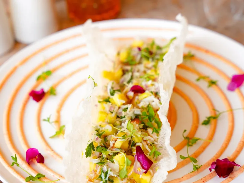 Morro-Xico : taco de crabe et mangue sur assiette rayée à La Coupole